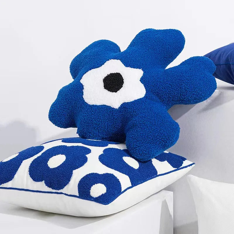 Bright blue flowers embroidered on a white 45x45cm pillow, creating a vibrant and elegant floral desig