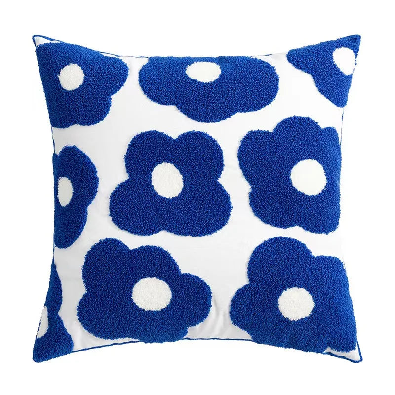 Bright blue flowers embroidered on a white 45x45cm pillow, creating a vibrant and elegant floral design.