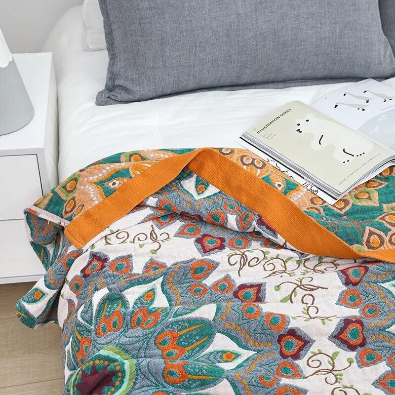 Folded throw with lotus mandala motifs and deep ochre trim, radiating intention and grounding energy