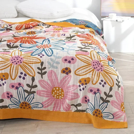 Soft cotton throw with woven line-drawn floral design in muted tones, crafted from breathable five-layer gauze
