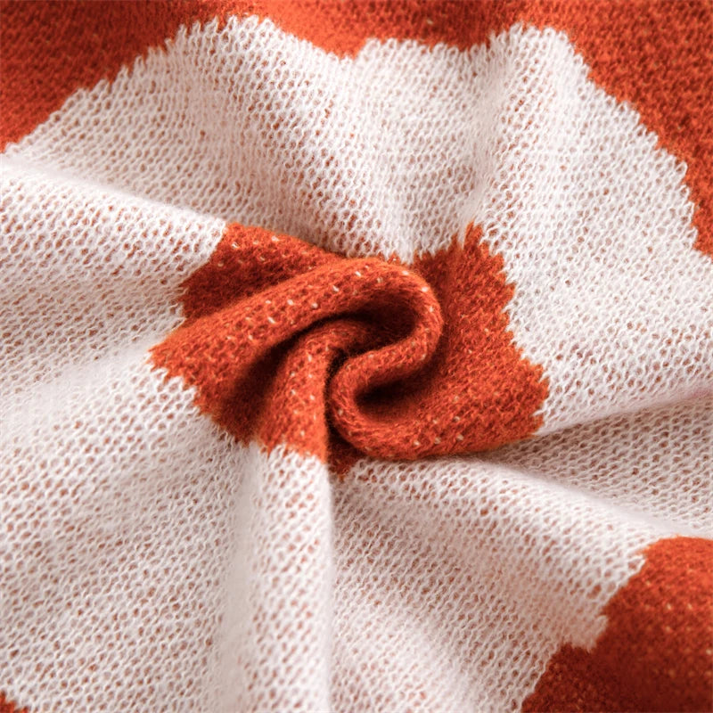 White and orange cotton blanket featuring oversized floral prints; soft woven texture with large summer flowers, ideal for draping over a chair, sofa
