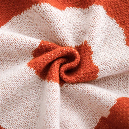 White and orange cotton blanket featuring oversized floral prints; soft woven texture with large summer flowers, ideal for draping over a chair, sofa