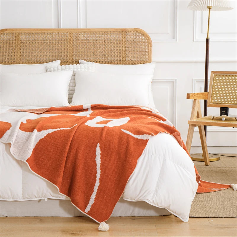White and orange cotton blanket featuring oversized floral prints; soft woven texture with large summer flowers, ideal for draping over a chair, sofa, or at the foot of the bed