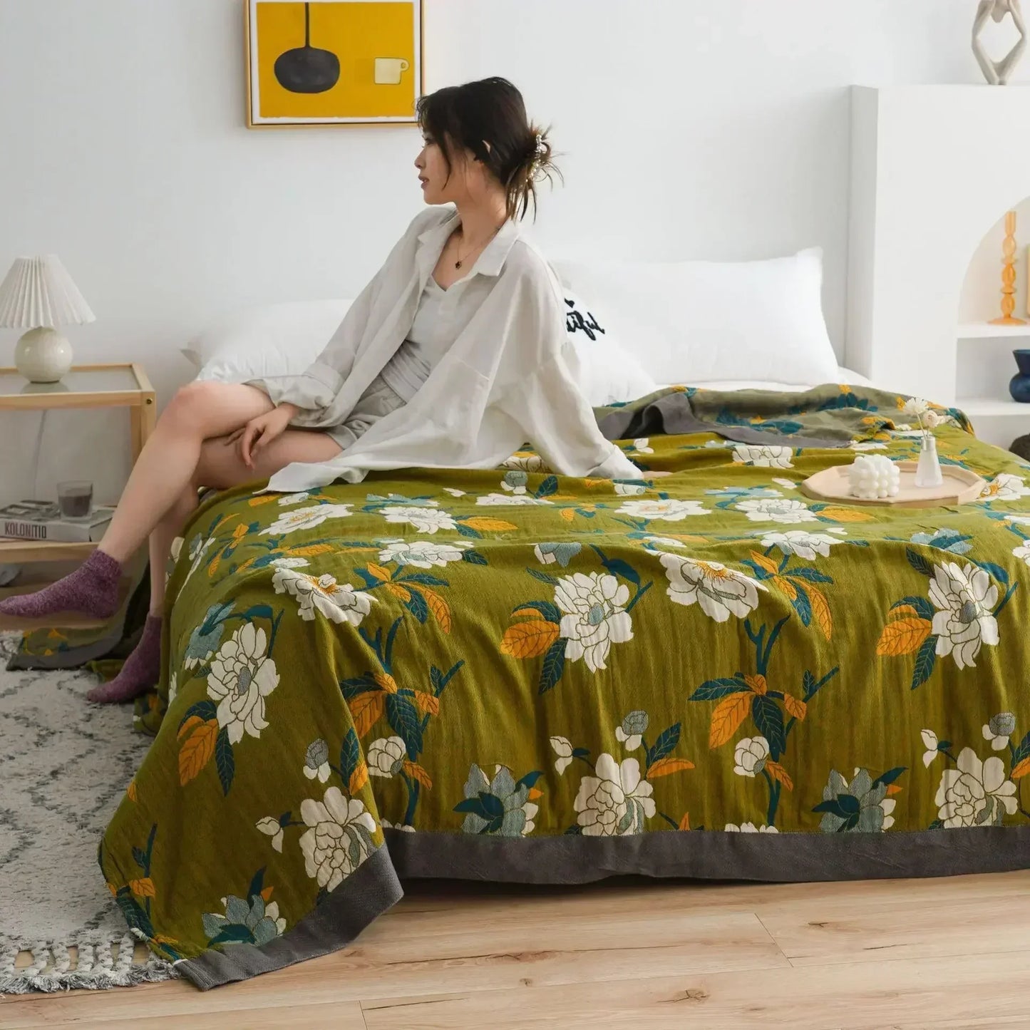 olive green throw with charcoal border and floral accents, symbolising quiet elegance and balance