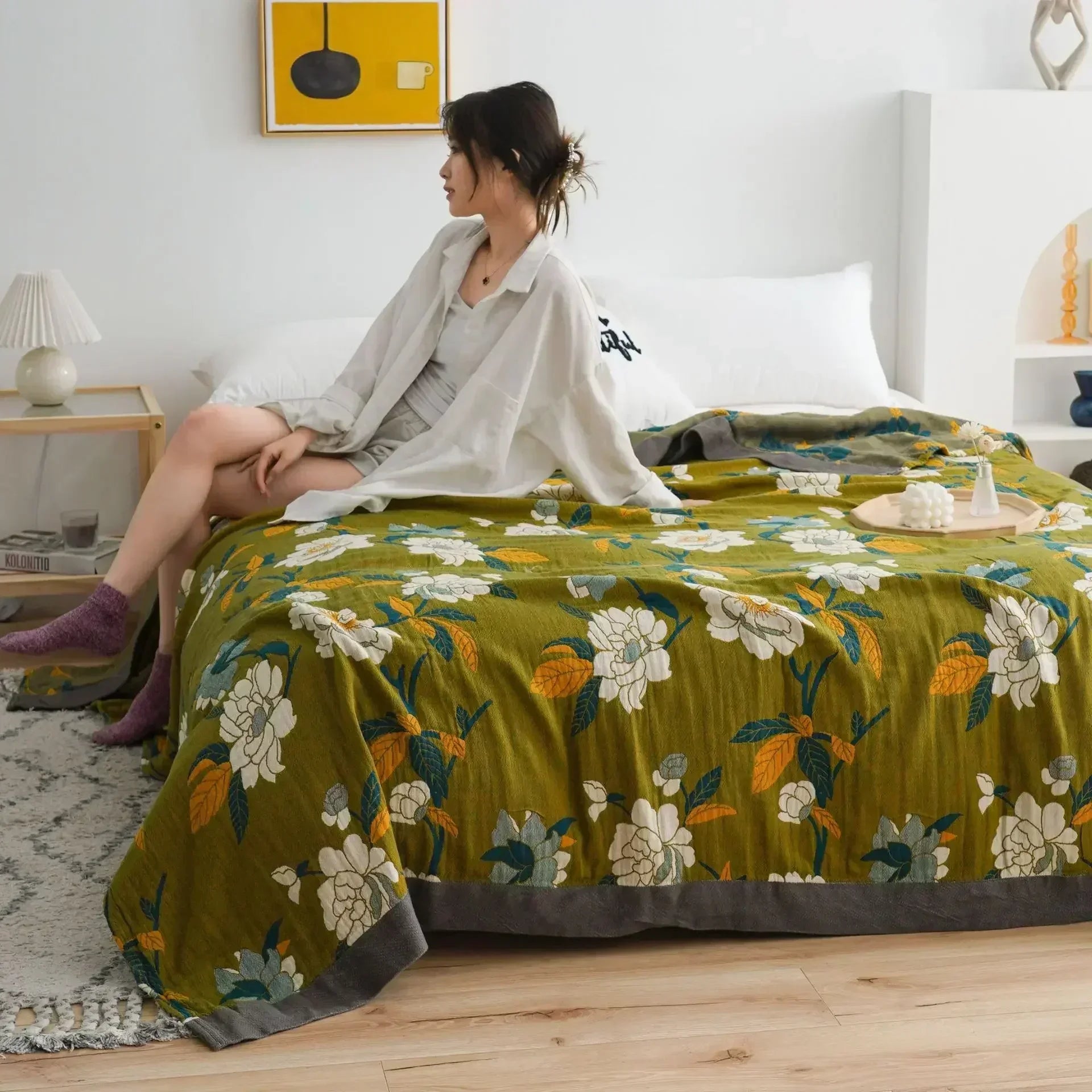 olive green throw with charcoal border and floral accents, symbolising quiet elegance and balance